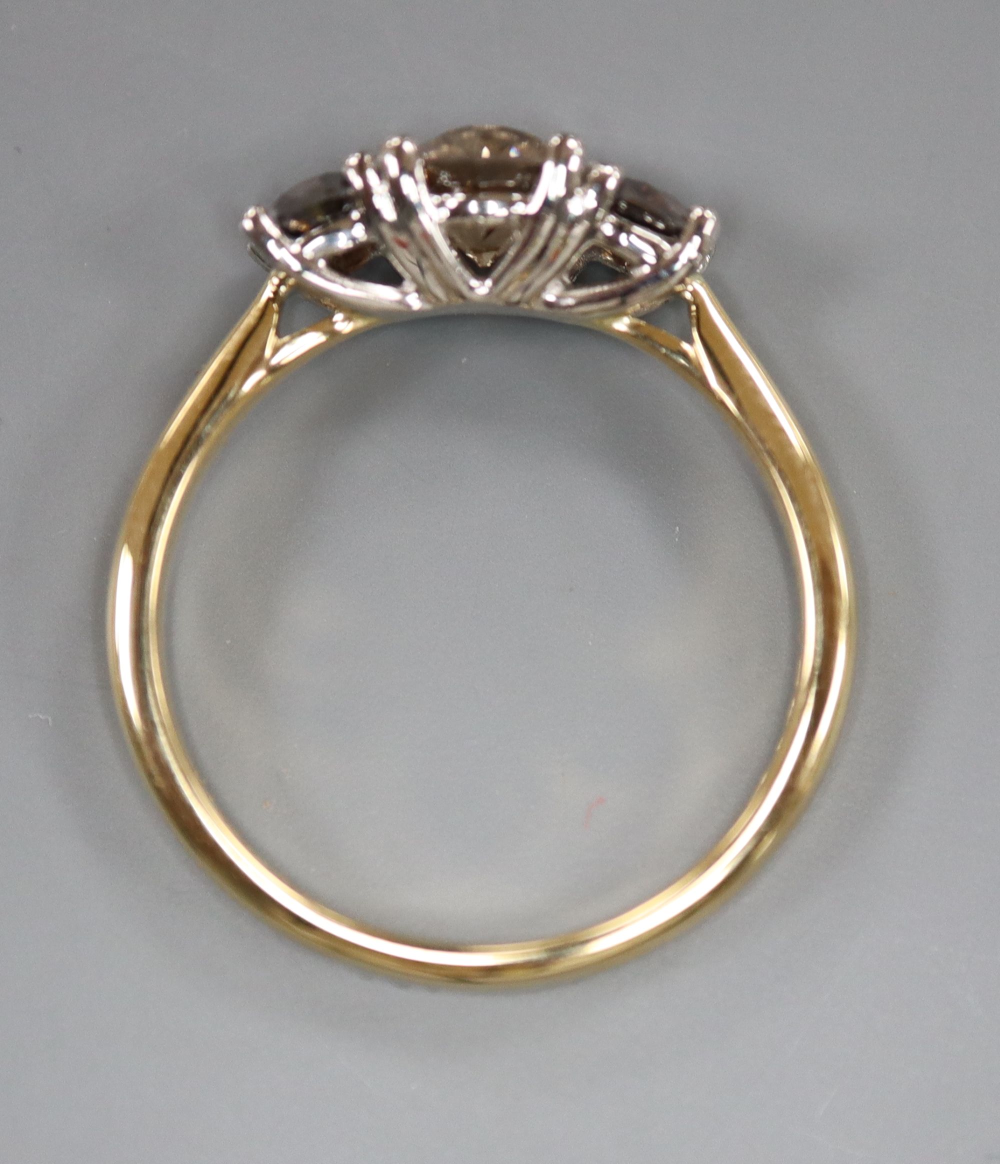 A modern 18ct gold and platinum, three stone two colour diamond set ring, size M, gross weight 3.5 grams.